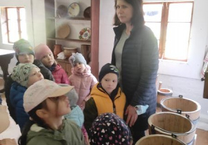 Dzieci oglądają wnętrze wiejskiej chałupy.